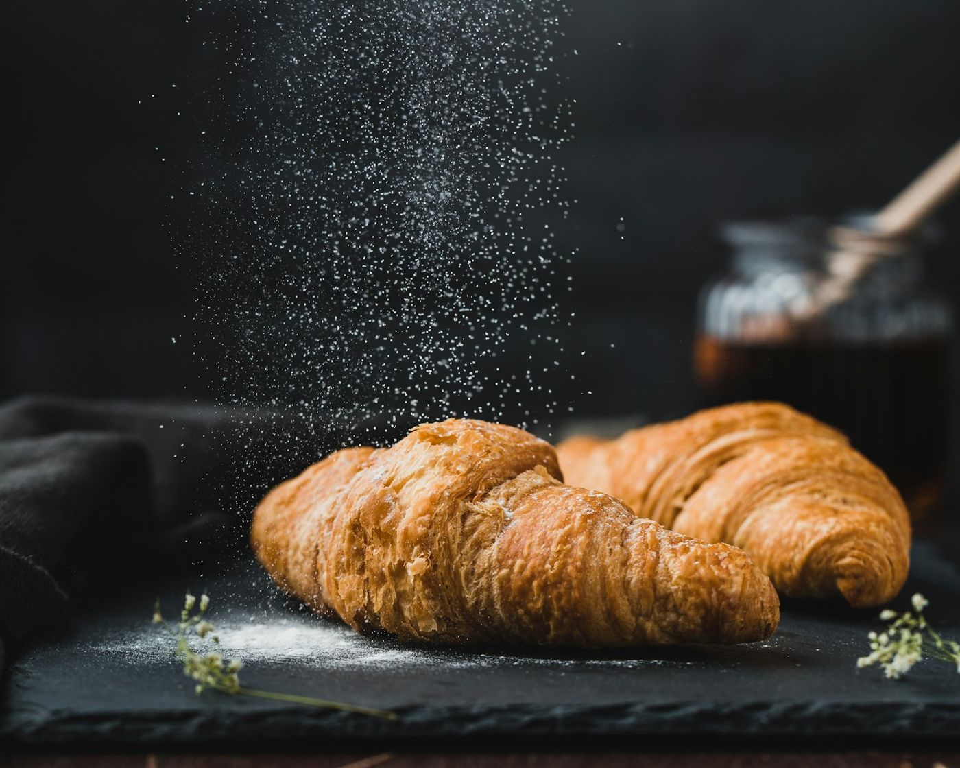 A croissant dusted with icing sugar