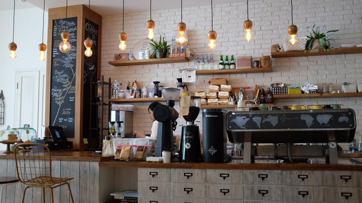 Inside The Outlook Cafe — espresso machine, chalkboard and warm pendant lights